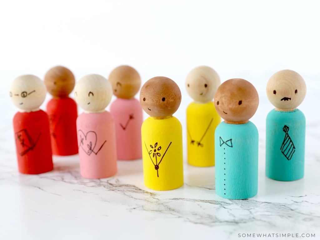 Wooden Spool Dolls lined up on a white counter