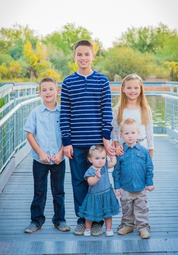 picture of 5 kids standing on a bridge