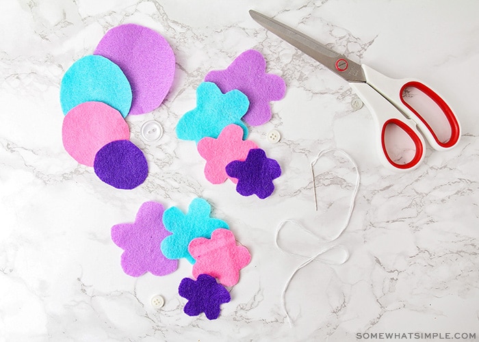 brightly colored felt shapes with scissors and thread