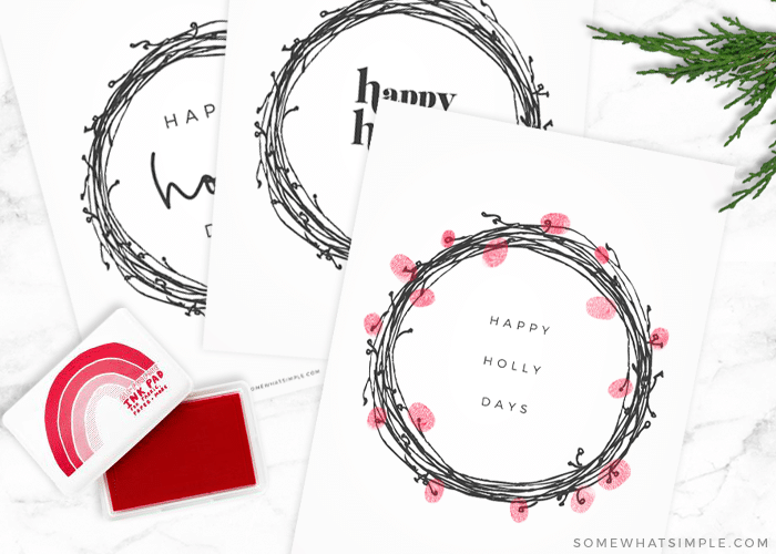 3 wreath prints, one with red fingerprints stamped around it to look like holly berries
