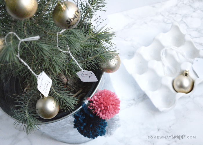 A small christmas tree in a metal tin with gold ornaments