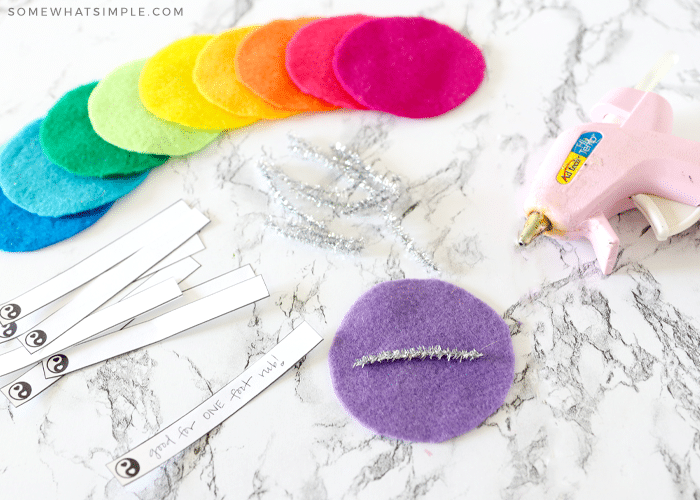 piece of purple felt with pipe cleaner on the inside laying on a counter next to a hot glue gun