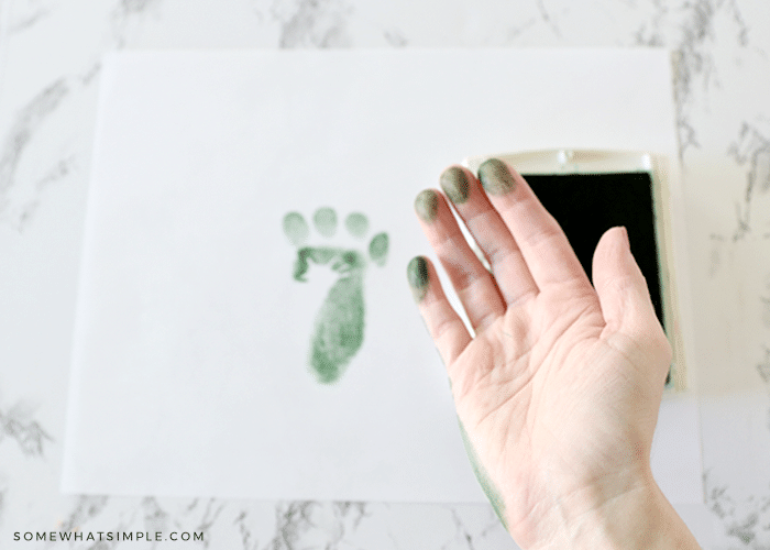 making footprints with a childs hand and a stamp pad