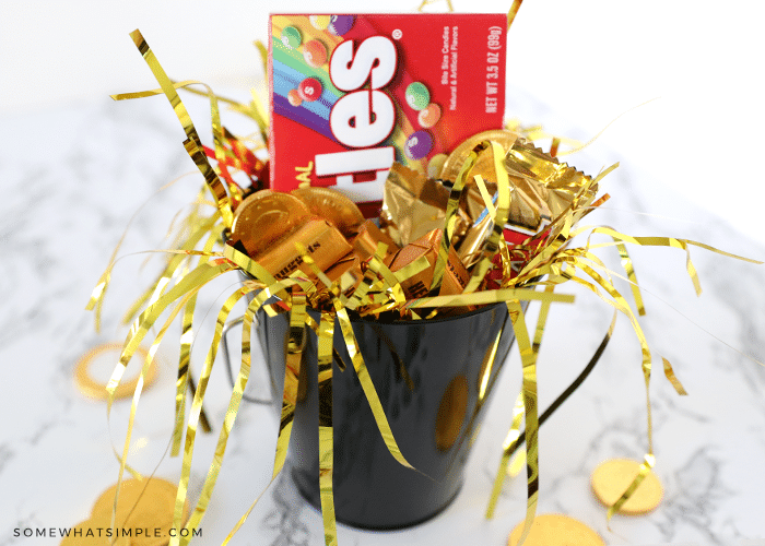 black tin bucket filled with gold confettit and candies