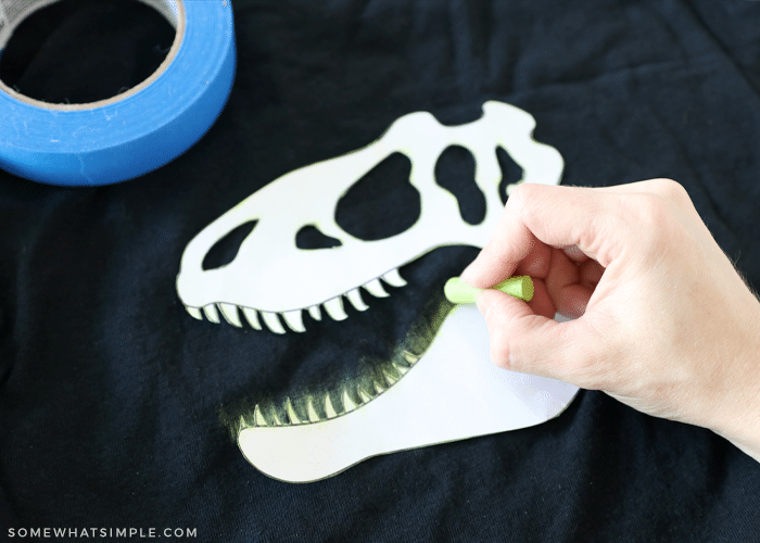 outlining a dinosaur face with chalk