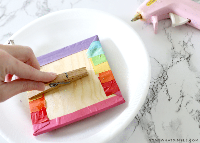 big clothes pin being glued to the back of a frame