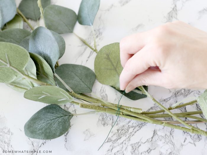 stacking more greenery on a wreath form