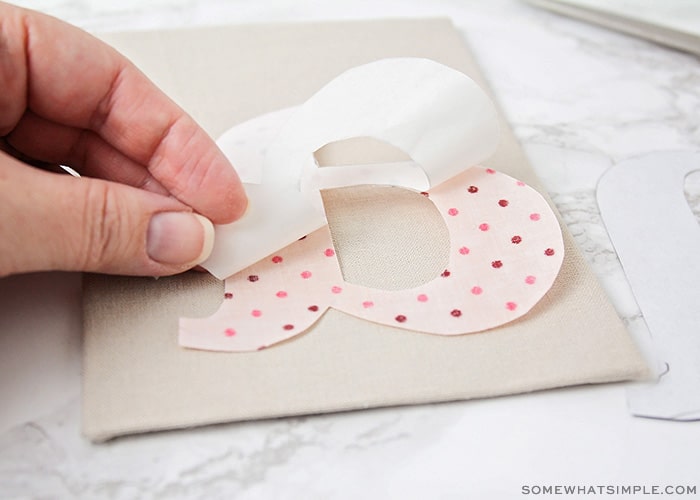 a fabric monogram being applied to a craft