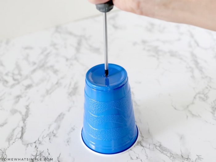 screwdriver puncturing plastic cup