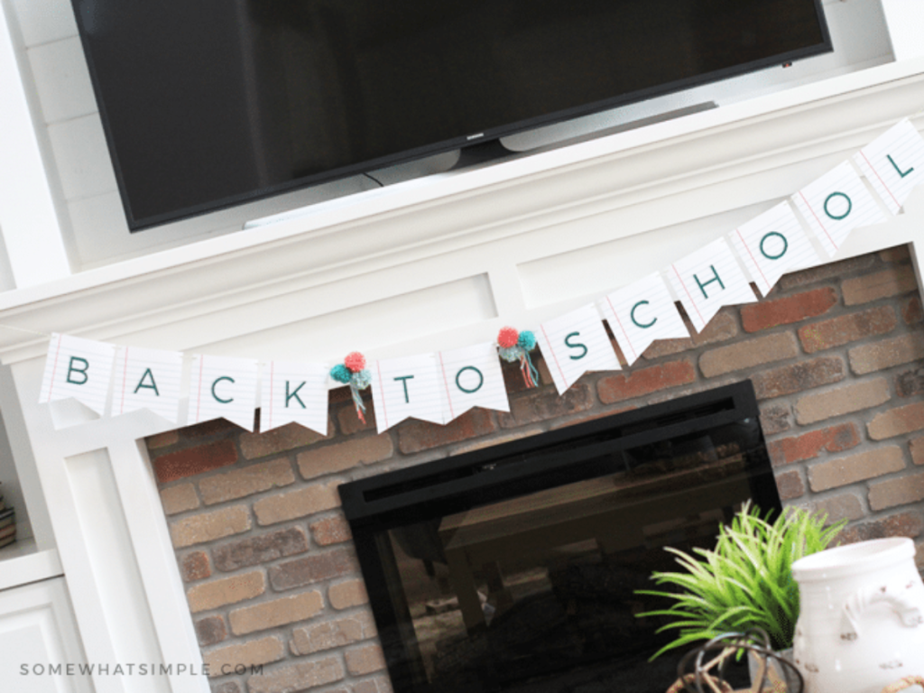 far off shot of a back to school banner hanging over a brick fireplace