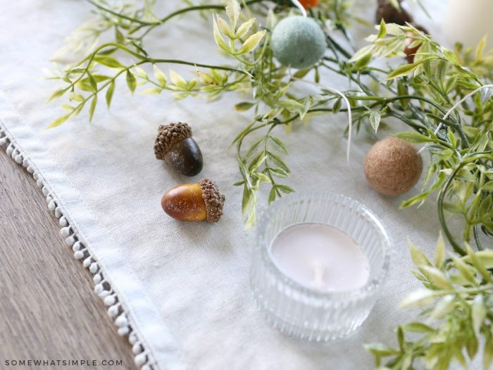 acorns placed around candles on a table