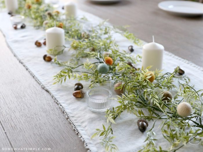 fall tablescape with acorns, greenery and candles