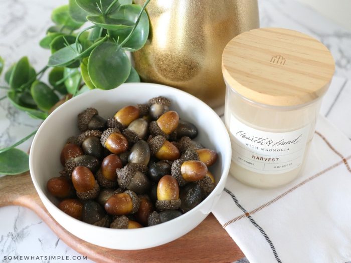 acorns in a bowl with a fall candle