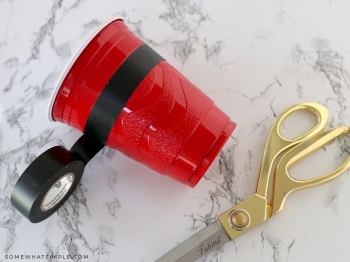 wrapping a red cup with black tape
