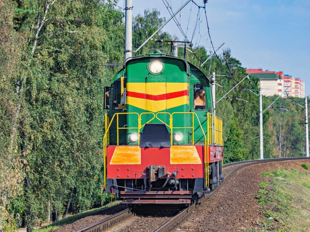 green, yellow and red train on the tracks