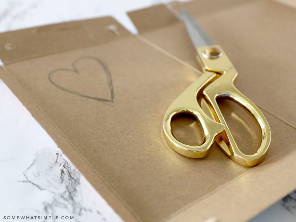 cutting out a cardboard heart stencil