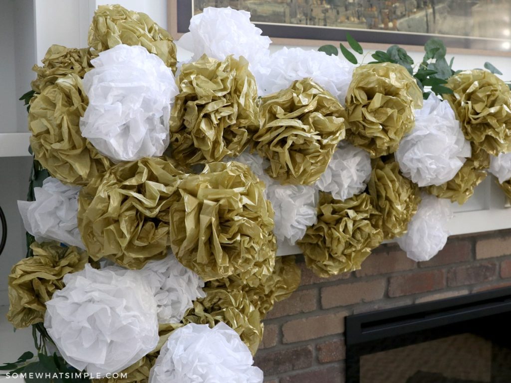 tissue paper pom poms on a christmas mantel