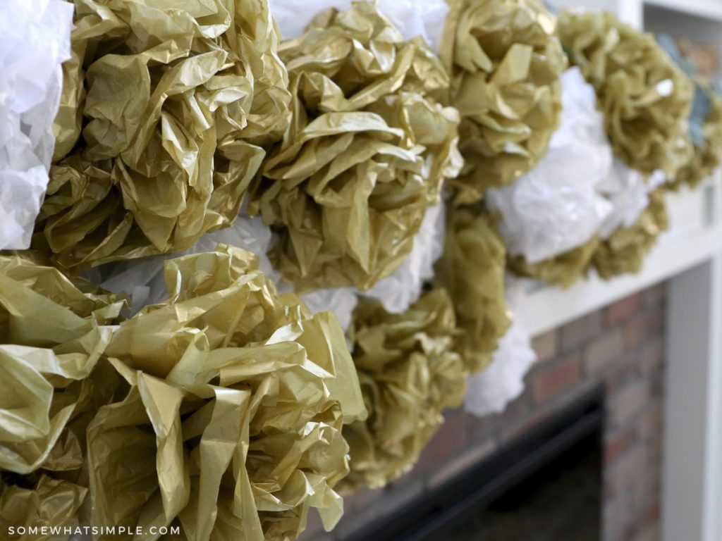 close up of gold and white pom poms made from tissue paper