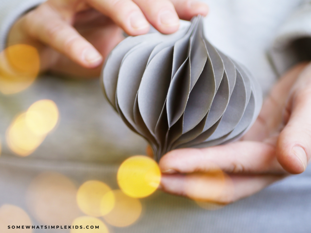 holding a handmade paper ornament