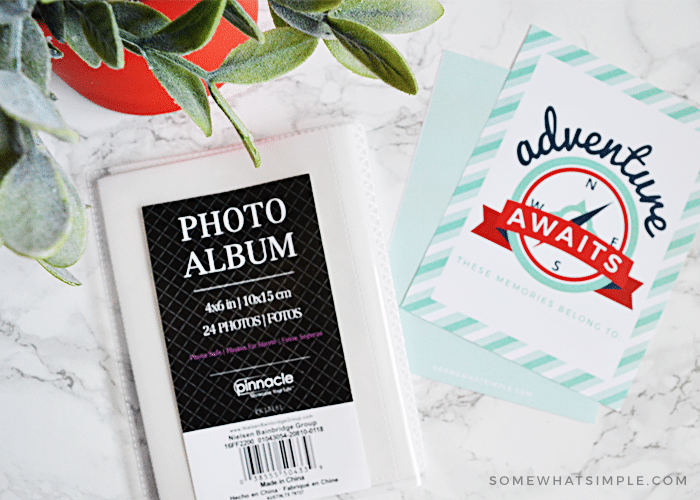 small photo album on a white counter with printable scrapbook page next to it