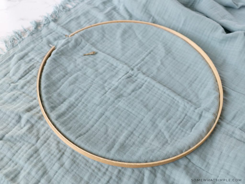 laying an embroidery hoop on a blanket to make a hanging play tent