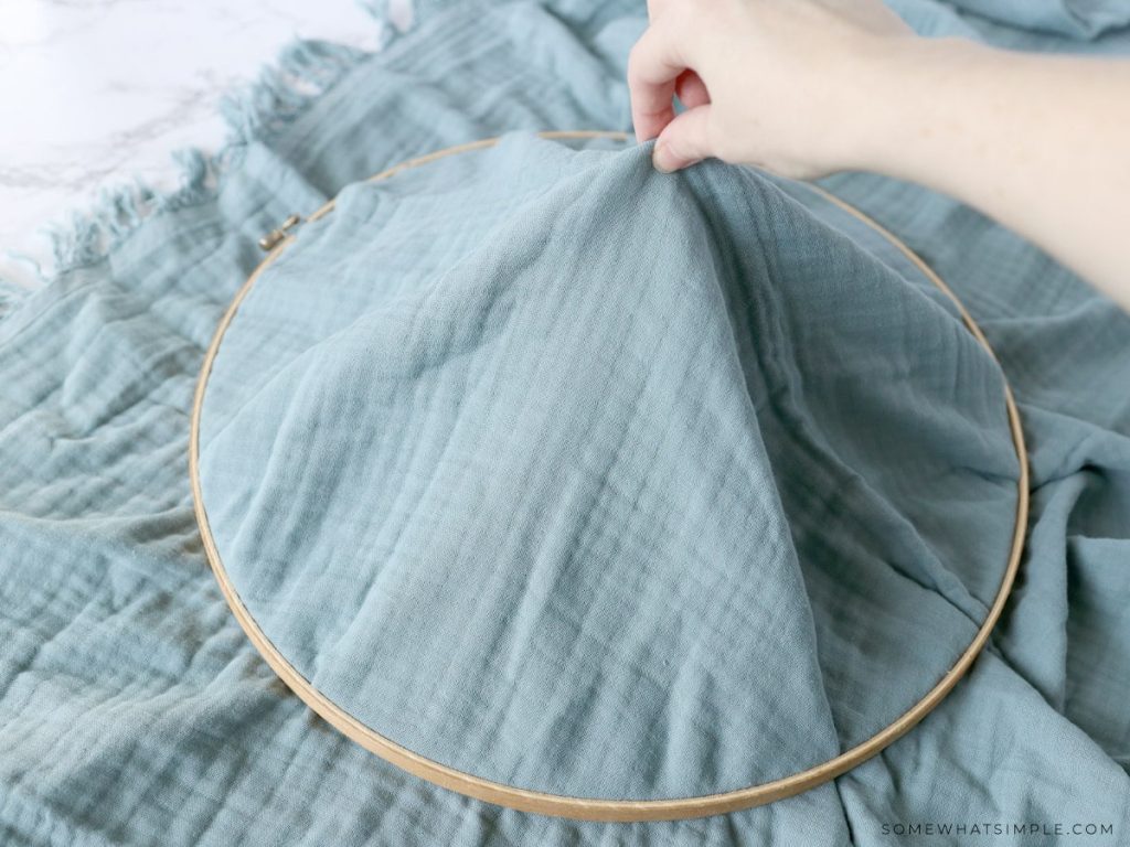 pulling up the center of a blanket to make a hanging play tent