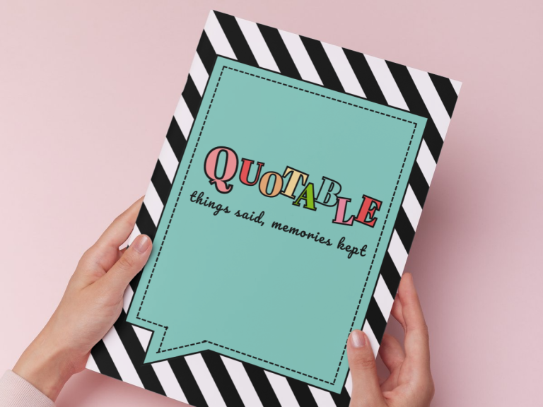 hands holding a quote book on a pink background